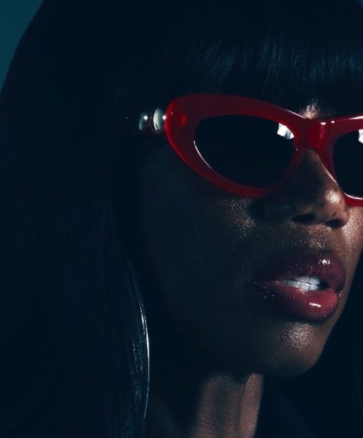 Shaznay Lewis pictured wearing red shades with glitter on her face