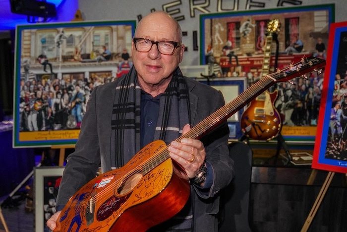 Mark Knopfler holds signed guitar